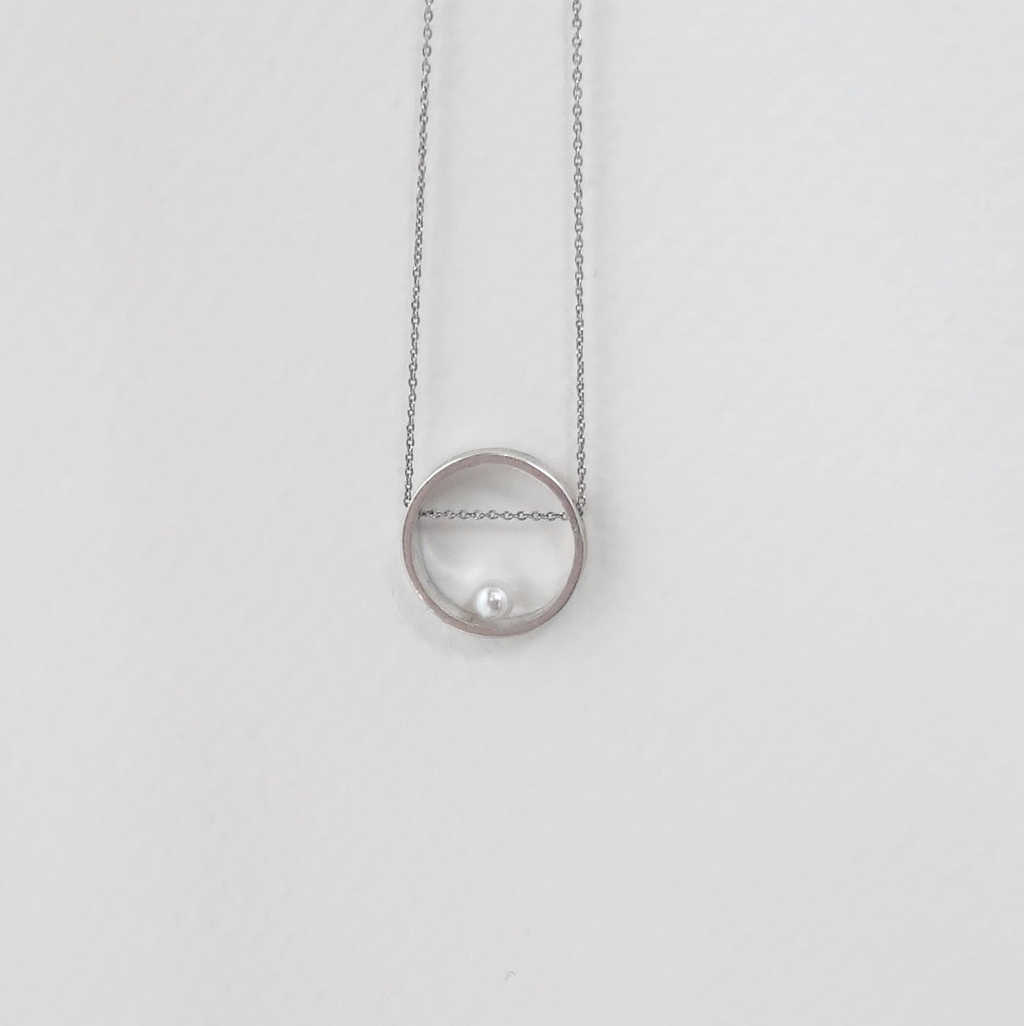 A detailed view of the handcrafted 925 sterling silver circle necklace featuring a round freshwater pearl, highlighting its delicate design.