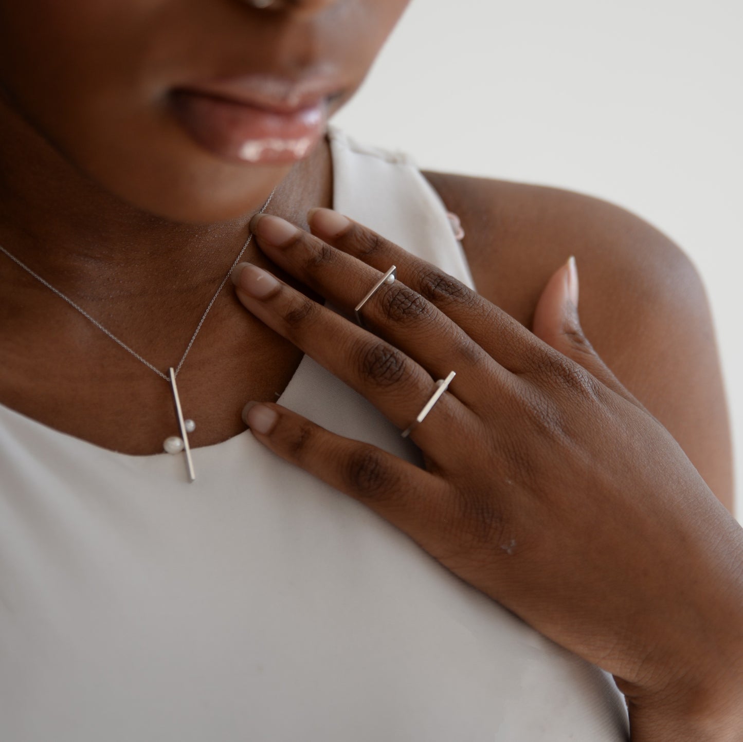 Model Wearing Linear Necklace: A person showcasing the elegant Linear Necklace, demonstrating its understated sophistication and perfect fit for everyday wear.