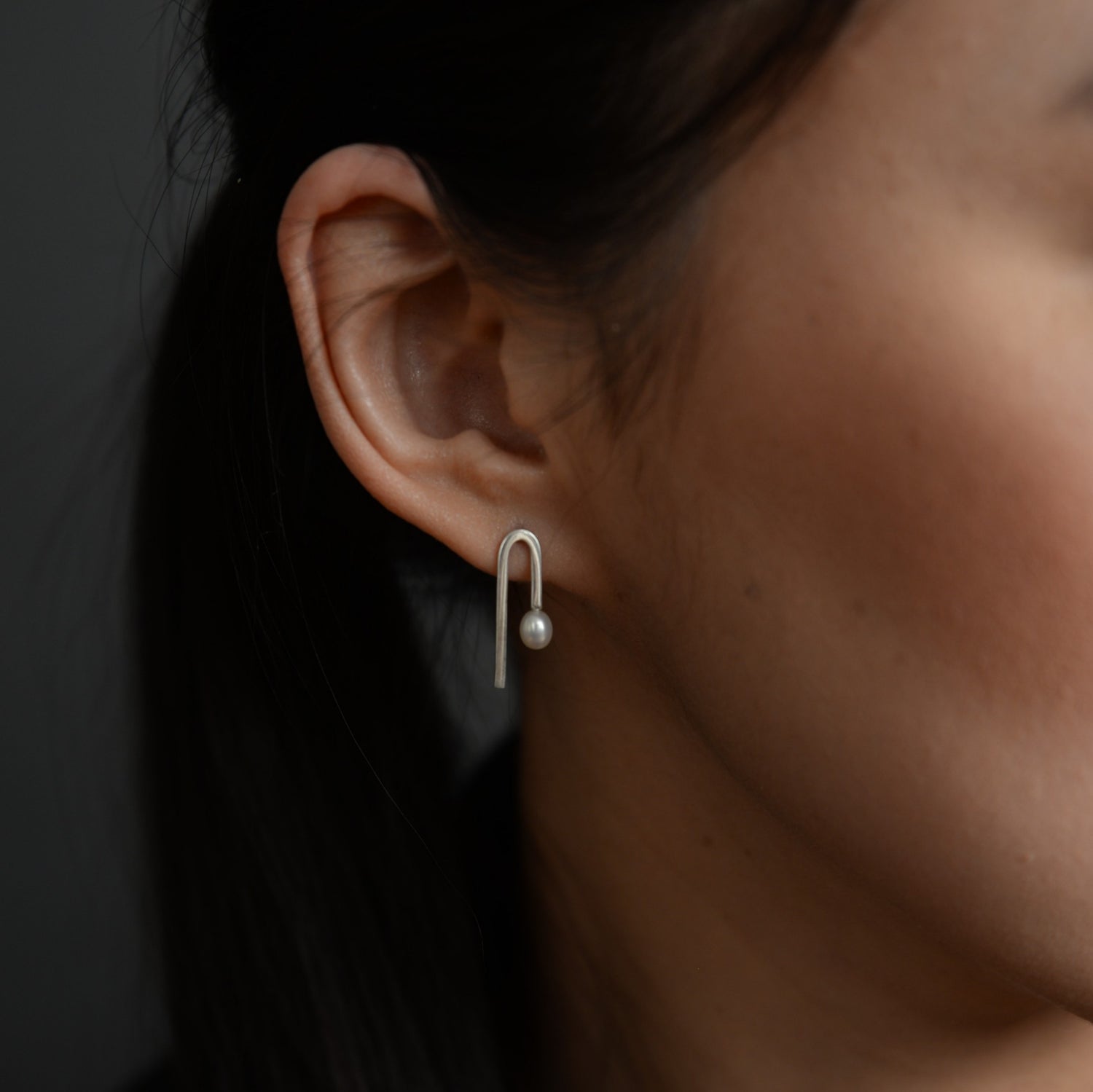 Model Wearing Flexion Earrings: A person showcasing the elegant Flexion Earrings, demonstrating their minimalist sophistication and perfect fit for everyday wear.