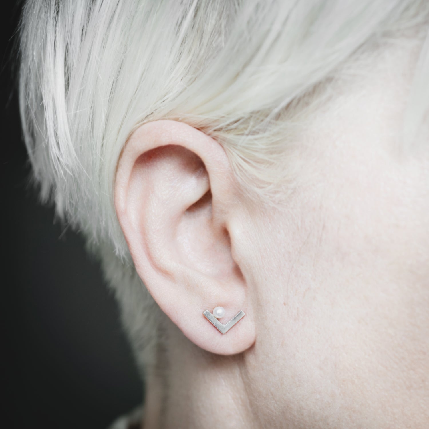 A woman showcasing the elegant Angle earrings, demonstrating their minimalist sophistication and perfect fit for everyday wear.