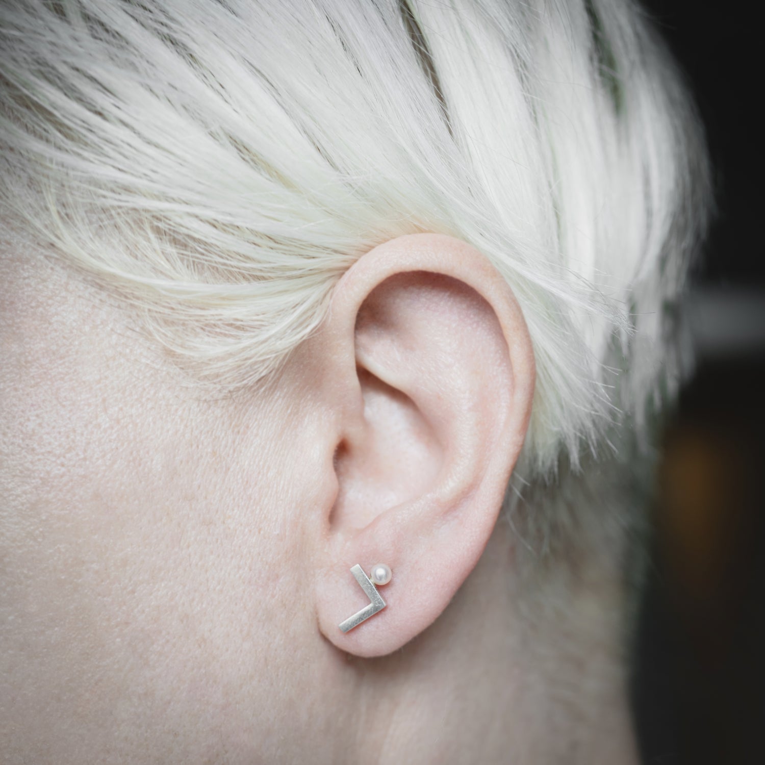 A woman showcasing the elegant Angle earrings, demonstrating their minimalist sophistication and perfect fit for everyday wear.